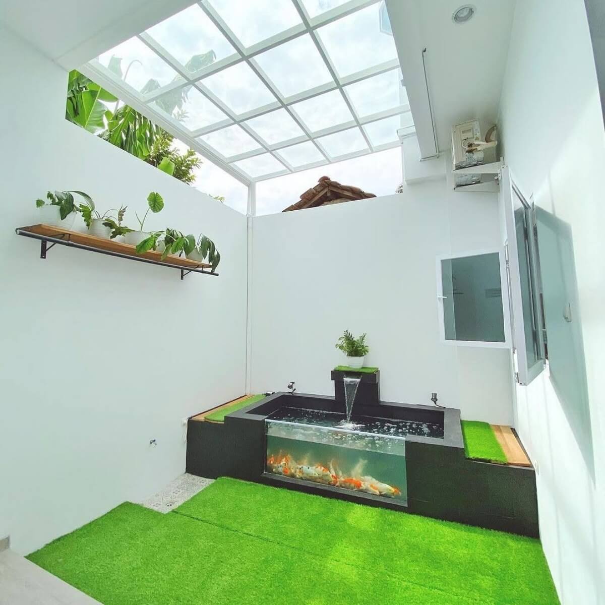 dekorasi taman rumput sintetis dengan kolam ikan