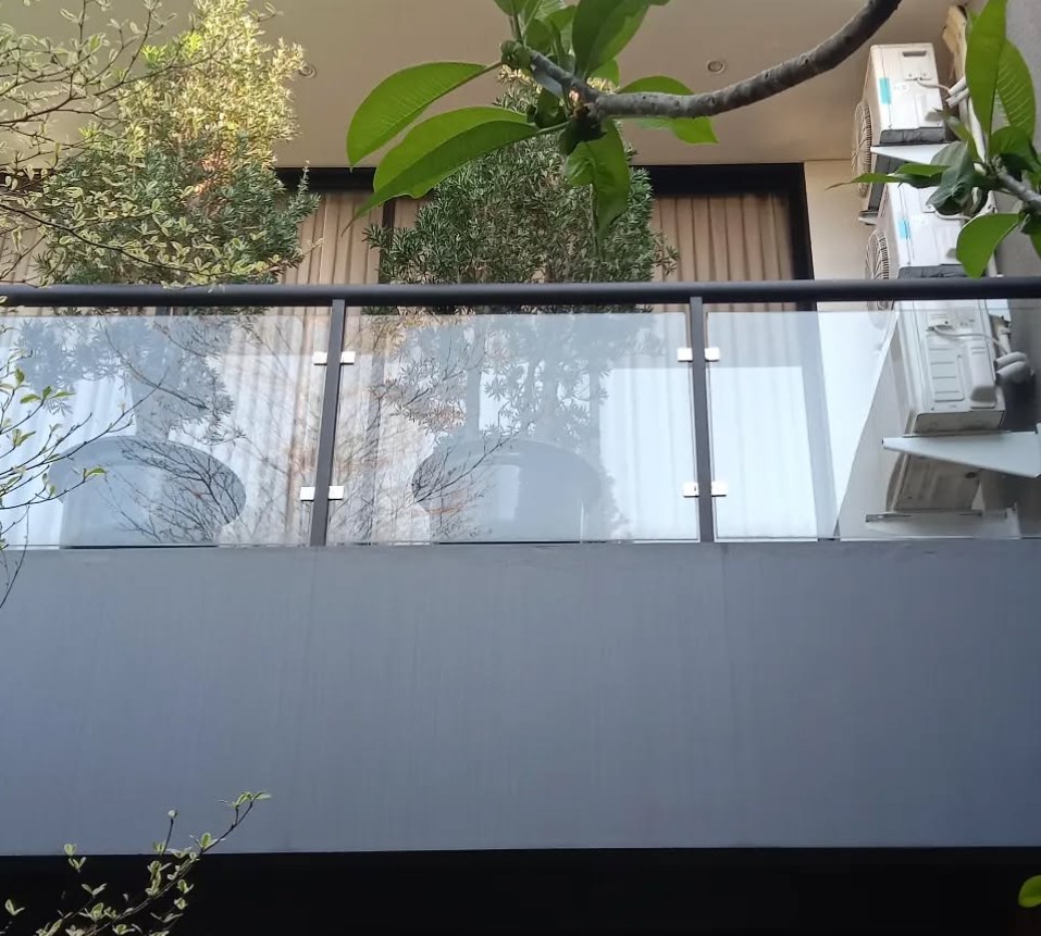 2. Model Balkon Kaca dengan Hiasan Tanaman Hijau